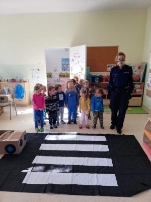 Policjanatka uczy dzieci przechodzenie przez przejście