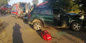 Miejsce zdarzenia drogowego, podczas pracy służb ratowniczych. Na zdjęciu rozbity pojazd Toyota na drzewie.