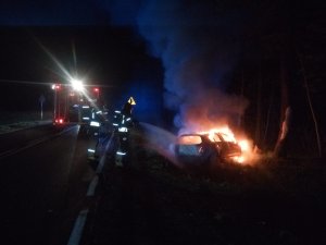 widok pojazdu płonącego pojazdu na drodze K51 podczas akcji gaśniczej