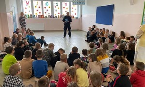 Policjant rozmawiający z dziećmi Szkoły Podstawowej nr 4 w Lidzbarku Warmińskim