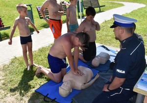 Policjant uczący dzieci resuscytacji krążeniowo-oddechowej