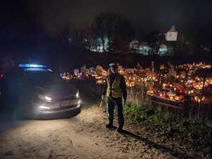 Policjant oraz samochód policyjny w rejonie cmentarza