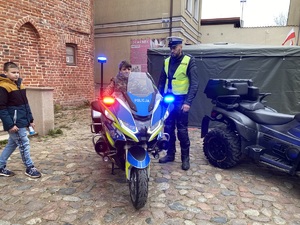 Policjant prezentujący motocykl policyjny