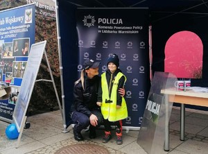 Policjantka z dzieckiem, które przymierzyło kamizelkę policyjną