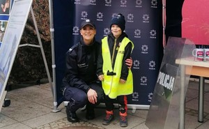 Policjantka z dzieckiem, które przymierzyło kamizelkę policyjną