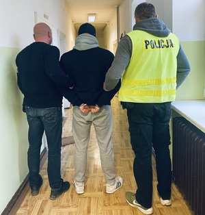 Policjanci prowadzący zatrzymanego poszukiwanego