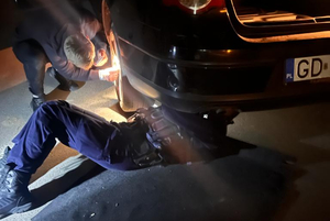 Policjant naprawiający samochód