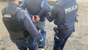 Policjanci prowadzący zatrzymanego mężczyznę