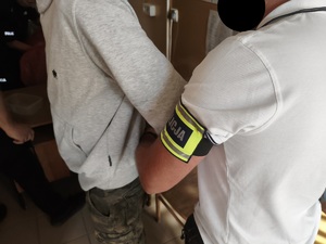 Policjant doprowadzający zatrzymanego